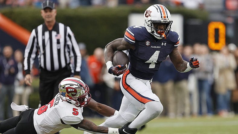 Nov 19, 2022; Auburn, Alabama, USA; Western Kentucky Hilltoppers defensive back Rome Weber (5) grabs Auburn Tigers running back Tank Bigsby (4) during the first quarter at Jordan-Hare Stadium. Mandatory Credit: John Reed-USA TODAY Sports