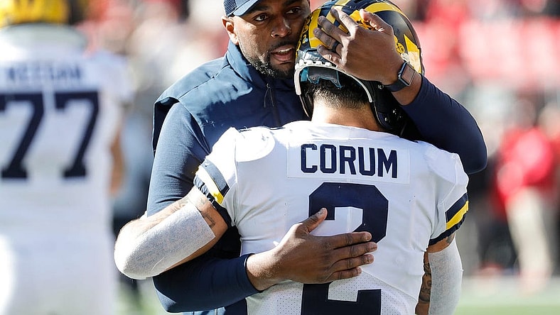 Michigan running back Blake Corum (2) is hugged by co-offensive coordinator Sherrone Moore during warmups before the game Nov. 26, 2022 against Ohio State at Ohio Stadium in Columbus.