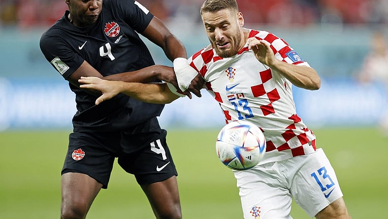 Nov 27, 2022; Doha, Qatar; Canada defender Kamal Miller (4) battles for the ball against Croatia midfielder Nikola Vlasic (13) during the second half of a group stage match during the 2022 World Cup at Khalifa International Stadium. Mandatory Credit: Yukihito Taguchi-USA TODAY Sports