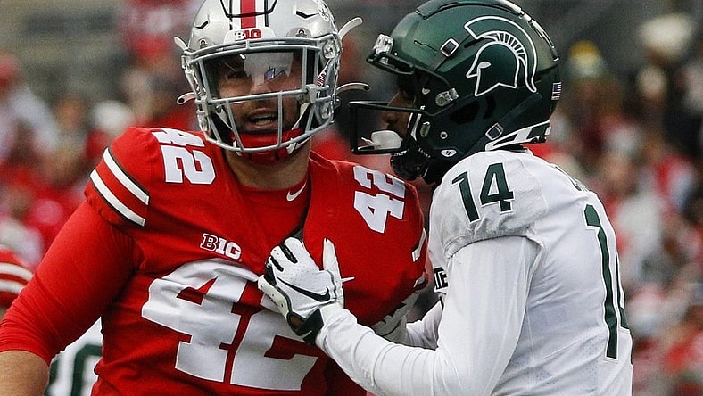 Michigan State Spartans cornerback Khary Crump (14) and Ohio State Buckeyes long snapper Bradley Robinson (42) share words after a punt return.

Syndication The Columbus Dispatch