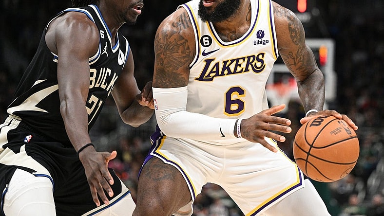 Dec 2, 2022; Milwaukee, Wisconsin, USA; Los Angeles Lakers forward LeBron James (6) posts up against Milwaukee Bucks guard Jrue Holiday (21) in the second quarter at Fiserv Forum. Mandatory Credit: Michael McLoone-USA TODAY Sports