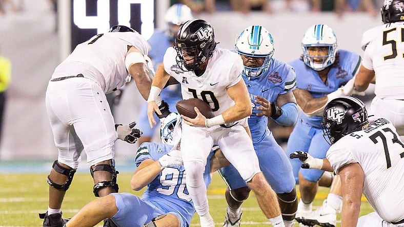 Dec 3, 2022; New Orleans, Louisiana, USA; UCF Knights quarterback John Rhys Plumlee (10) scrambles away from Tulane Green Wave defensive lineman Patrick Jenkins (0) during the second half at Yulman Stadium. Mandatory Credit: Stephen Lew-USA TODAY Sports