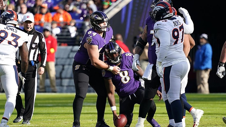 Dec 4, 2022; Baltimore, Maryland, USA; Baltimore Ravens quarterback Lamar Jackson (8) is helped to his feet by center Tyler Linderbaum (64) after being sacked by the Denver Broncos at M&T Bank Stadium. Mandatory Credit: Mitch Stringer-USA TODAY Sports