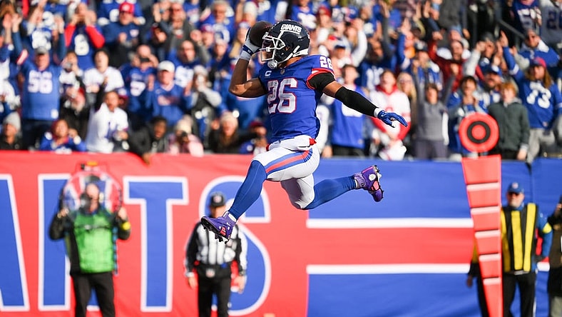 Dec 4, 2022; East Rutherford, New Jersey, USA; New York Giants running back Saquon Barkley (26) leaps into the end zone for a touchdown against the Washington Commanders during the first half at MetLife Stadium. Mandatory Credit: Rich Barnes-USA TODAY Sports
