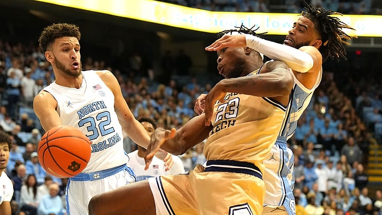 Dec 10, 2022; Chapel Hill, North Carolina, USA; North Carolina Tar Heels forward Pete Nance (32) and guard R.J. Davis (4) and Georgia Tech Yellow Jackets forward Jordan Meka (23) fight for the ball in the first half at Dean E. Smith Center. Mandatory Credit: Bob Donnan-USA TODAY Sports