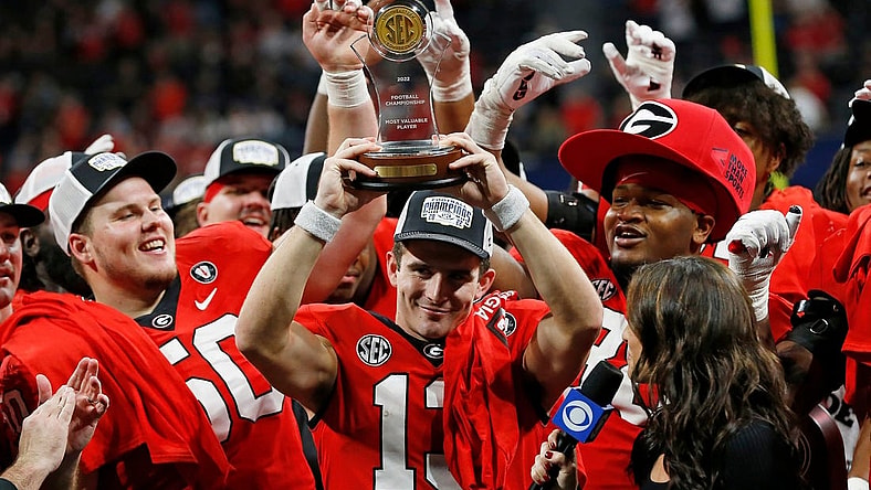 Georgia quarterback Stetson Bennett (13) raises the SEC Championship MVP trophy after the SEC Championship NCAA college football game between LSU and Georgia in Atlanta, on Saturday, Dec. 3, 2022. Georgia won 50-30.

News Joshua L Jones