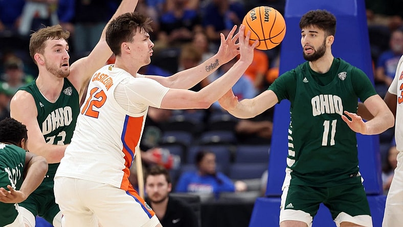 Dec 14, 2022; Tampa, Florida, USA; Florida Gators forward Colin Castleton (12) passes the ball past Ohio Bobcats center Gabe Wiznitzer (11) during the first half at Amalie Arena. Mandatory Credit: Kim Klement-USA TODAY Sports