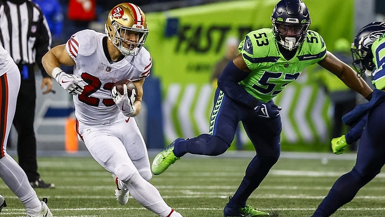 Dec 15, 2022; Seattle, Washington, USA; San Francisco 49ers running back Christian McCaffrey (23) rushes against the Seattle Seahawks during the second quarter at Lumen Field. Seattle Seahawks linebacker Boye Mafe (53) follows the play at right. Mandatory Credit: Joe Nicholson-USA TODAY Sports