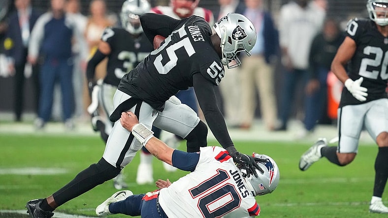 Dec 18, 2022; Paradise, Nevada, USA; Las Vegas Raiders defensive end Chandler Jones (55) stiff-arms New England Patriots quarterback Mac Jones (10) on the way to scoring a touchdown at the end of the second half at Allegiant Stadium. Mandatory Credit: Stephen R. Sylvanie-USA TODAY Sports