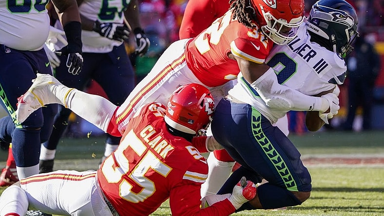 Dec 24, 2022; Kansas City, Missouri, USA; Seattle Seahawks running back Kenneth Walker III (9) is tackled by Kansas City Chiefs defensive end Frank Clark (55) and linebacker Nick Bolton (32) during the first half at GEHA Field at Arrowhead Stadium. Mandatory Credit: Denny Medley-USA TODAY Sports