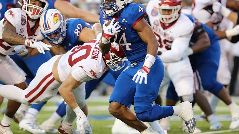 Dec 28, 2022; Memphis, TN, USA; Kansas Jayhawks running back Devin Neal (4) rushes against the Arkansas Razorbacks in the first quarter in the 2022 Liberty Bowl at Liberty Bowl Memorial Stadium. Mandatory Credit: Nelson Chenault-USA TODAY Sports