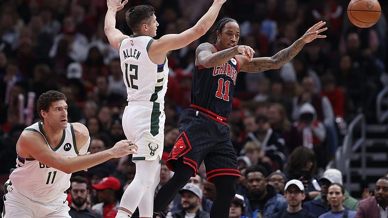 Dec 28, 2022; Chicago, Illinois, USA; Chicago Bulls forward DeMar DeRozan (11) passes the ball away from Milwaukee Bucks guard Grayson Allen (12) during the first half at United Center. Mandatory Credit: Kamil Krzaczynski-USA TODAY Sports