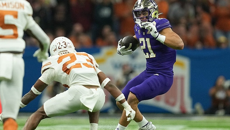 Dec 29, 2022; San Antonio, Texas, USA;  Washington Huskies running back Wayne Taulapapa (21) cuts back in front of Texas Longhorns defensive back Jahdae Barron during the first half in the 2022 Alamo Bowl at the Alamodome. Mandatory Credit: Daniel Dunn-USA TODAY Sports