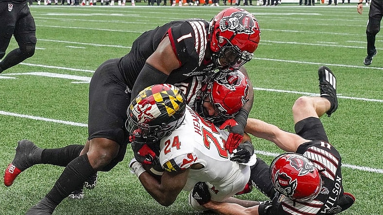 Dec 30, 2022; Charlotte, NC, USA; North Carolina State Wolfpack linebacker Isaiah Moore (1) and linebacker Payton Wilson (11) stop Maryland Terrapins running back Roman Hemby (24) on fourth down during the first half in the 2022 Duke's Mayo Bowl at Bank of America Stadium. Mandatory Credit: Jim Dedmon-USA TODAY Sports