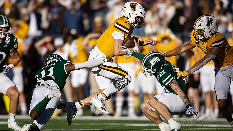 Dec 30, 2022; Tucson, AZ, USA; Wyoming Cowboys quarterback Andrew Peasley (6) runs the ball against Ohio Bobcats safety Tariq Drake (11) and cornerback Austin Brawley (21) in the first half of the 2022 Barstool Sports Arizona Bowl at Arizona Stadium. Mandatory Credit: Mark J. Rebilas-USA TODAY Sports