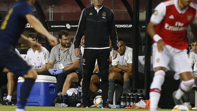 Jul 23, 2019; Landover, MD, USA; Real Madrid head coach Zinedine Zidane (M) looks on from the bench against Arsenal in the second half of a match in the International Champions Cup soccer series at FedEx Field. Real Madrid won 2-2 (3-2 pen.). Mandatory Credit: Geoff Burke-USA TODAY Sports