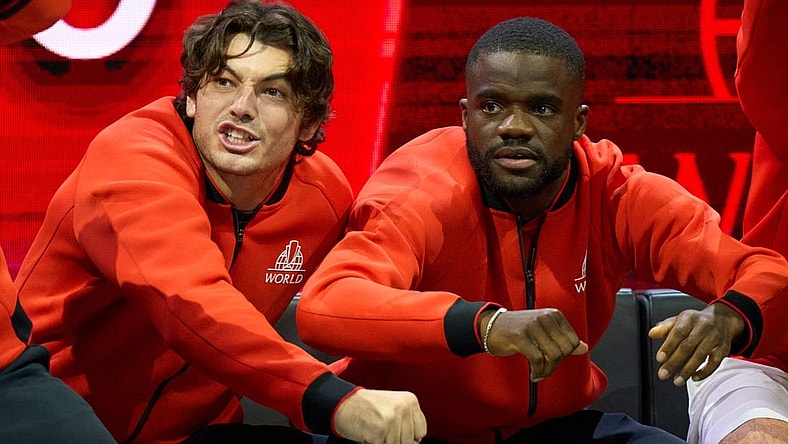 Sep 23, 2022; London, United Kingdom;  Team World players, Taylor Fritz (USA) and Frances Tiafoe (USA),  show their support in the Laver Cup tennis match between Andy Murray (GBR) and Alex De Minaur (AUS) as Team World captain John McEnroe looks on.  Mandatory Credit: Peter van den Berg-USA TODAY Sports