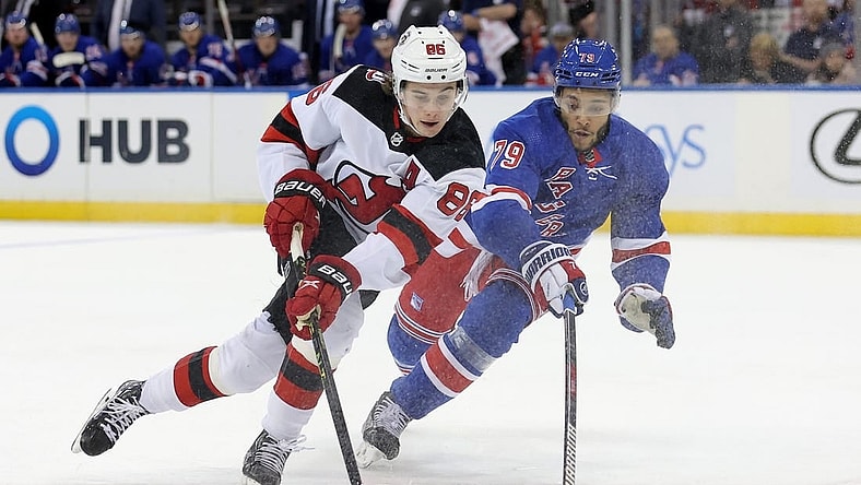 Dec 12, 2022; New York, New York, USA; New York Rangers defenseman K'Andre Miller (79) knocks the puck away from New Jersey Devils center Jack Hughes (86) during the first period at Madison Square Garden. Mandatory Credit: Brad Penner-USA TODAY Sports