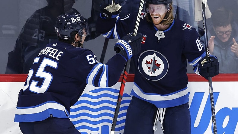 Dec 15, 2022; Winnipeg, Manitoba, CAN; Winnipeg Jets center Mark Scheifele (55) celebrates the overtime goal by Winnipeg Jets left wing Kyle Connor (81) against the Nashville Predators at Canada Life Centre. Mandatory Credit: James Carey Lauder-USA TODAY Sports