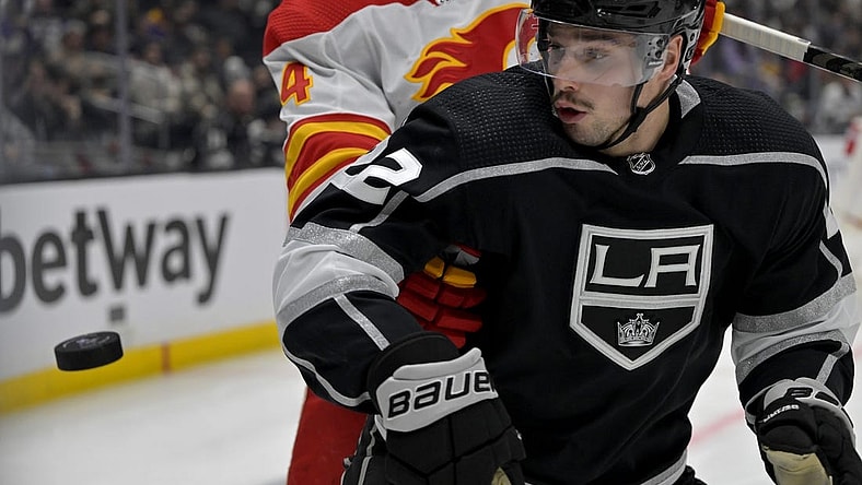 Dec 22, 2022; Los Angeles, California, USA; Calgary Flames defenseman Rasmus Andersson (4) and Los Angeles Kings left wing Kevin Fiala (22) go for the puck in the second period at Crypto.com Arena. Mandatory Credit: Jayne Kamin-Oncea-USA TODAY Sports