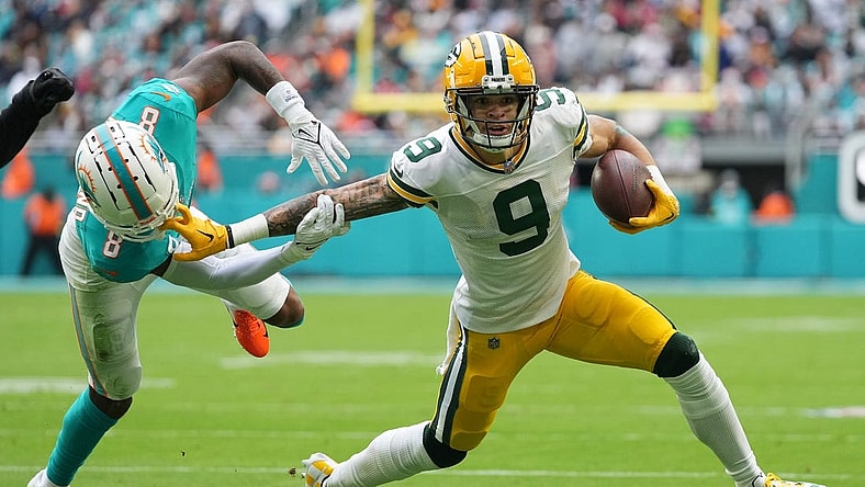 Dec 25, 2022; Miami Gardens, Florida, USA; Miami Dolphins safety Jevon Holland (8) attempts to tackle Green Bay Packers wide receiver Christian Watson (9) during the first half at Hard Rock Stadium. Mandatory Credit: Jasen Vinlove-USA TODAY Sports