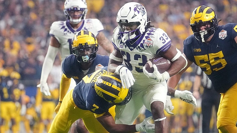 Dec 31, 2022; Glendale, Arizona, USA; TCU Horned Frogs running back Kendre Miller (33) tries to break away from Michigan Wolverines Makari Paige (7) past during the Vrbo Fiesta Bowl at State Farm Stadium. Mandatory Credit: Joe Rondone-Arizona Republic

Ncaa Fiesta Bowl Game