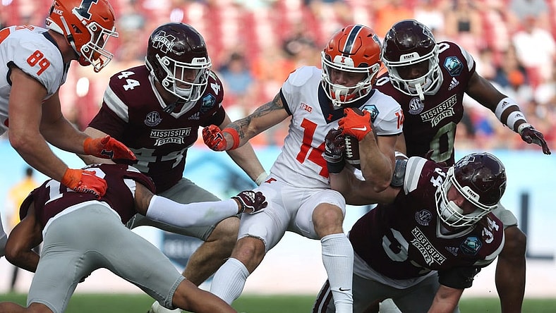 Jan 2, 2023; Tampa, FL, USA; Illinois Fighting Illini wide receiver Casey Washington (14) runs with the ball as Mississippi State Bulldogs linebacker Jett Johnson (44) and linebacker Sherman Timbs (34) defends during the first half in the 2023 ReliaQuest Bowl at Raymond James Stadium. Mandatory Credit: Kim Klement-USA TODAY Sports