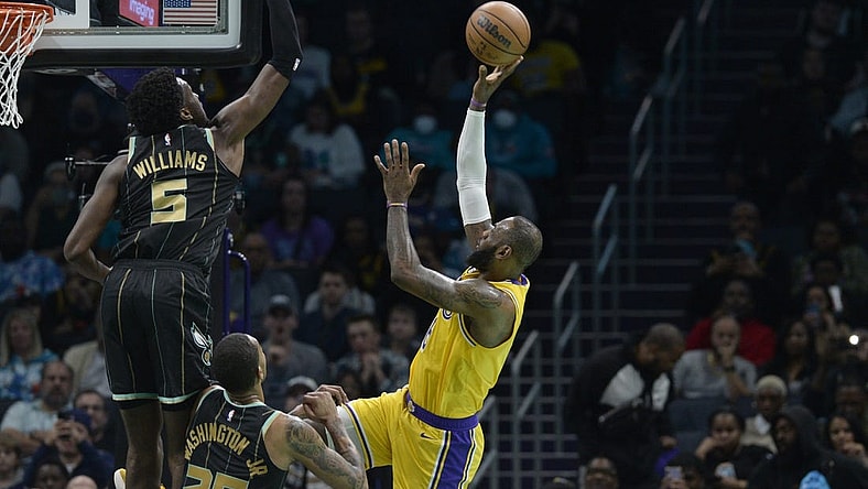 Jan 2, 2023; Charlotte, North Carolina, USA; Los Angeles Lakers forward LeBron James (6) shoots as he is defended by Charlotte Hornets center Mark Williams (5) and forward P.J. Washington (25) during first half at the Spectrum Center. Mandatory Credit: Sam Sharpe-USA TODAY Sports