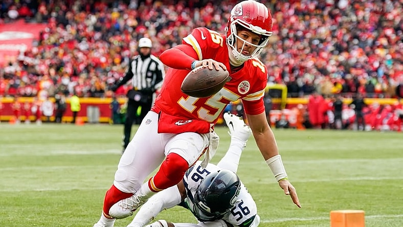 Dec 24, 2022; Kansas City, Missouri, USA; Kansas City Chiefs quarterback Patrick Mahomes (15) runs for a touchdown against Seattle Seahawks linebacker Jordyn Brooks (56) during the second half at GEHA Field at Arrowhead Stadium. Mandatory Credit: Jay Biggerstaff-USA TODAY Sports