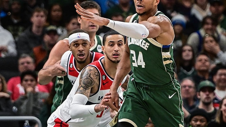 Jan 3, 2023; Milwaukee, Wisconsin, USA; Milwaukee Bucks forward Giannis Antetokounmpo (34) passes the ball away from Washington Wizards forward Kyle Kuzma (33) in the first quarter at Fiserv Forum. Mandatory Credit: Benny Sieu-USA TODAY Sports