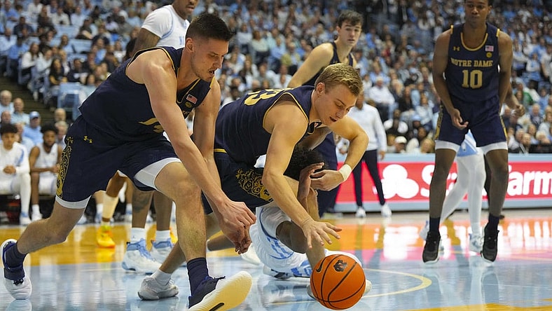 Jan 7, 2023; Chapel Hill, North Carolina, USA;  Notre Dame Fighting Irish guard Dane Goodwin (23) and forward Nate Laszewski (14) got after the loose ball against the North Carolina Tar Heels during the second half at Dean E. Smith Center. Mandatory Credit: James Guillory-USA TODAY Sports