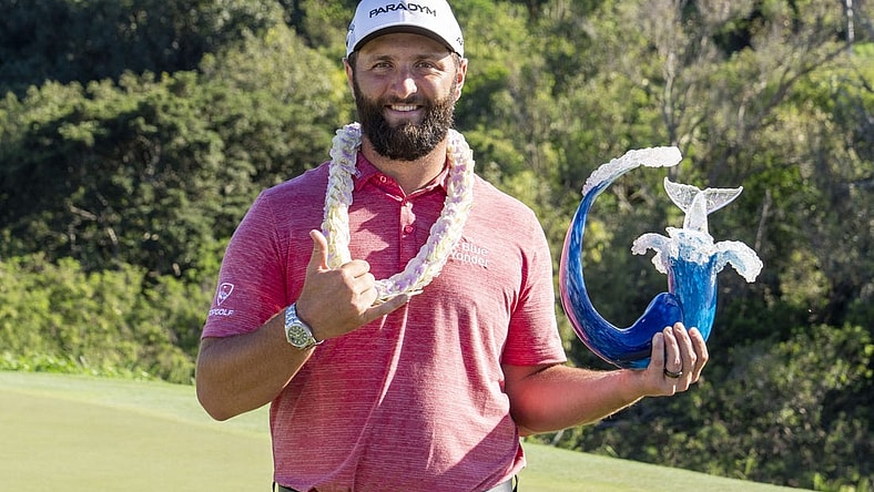 January 8, 2023; Maui, Hawaii, USA; Jon Rahm hoists the trophy on the 18th hole during the final round of the Sentry Tournament of Champions golf tournament at Kapalua Resort - The Plantation Course. Mandatory Credit: Kyle Terada-USA TODAY Sports