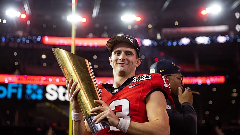 Jan 9, 2023; Inglewood, CA, USA; Georgia Bulldogs quarterback Stetson Bennett (13) celebrates with the championship trophy after defeating the TCU Horned Frogs during the CFP national championship game at SoFi Stadium. Mandatory Credit: Mark J. Rebilas-USA TODAY Sports
