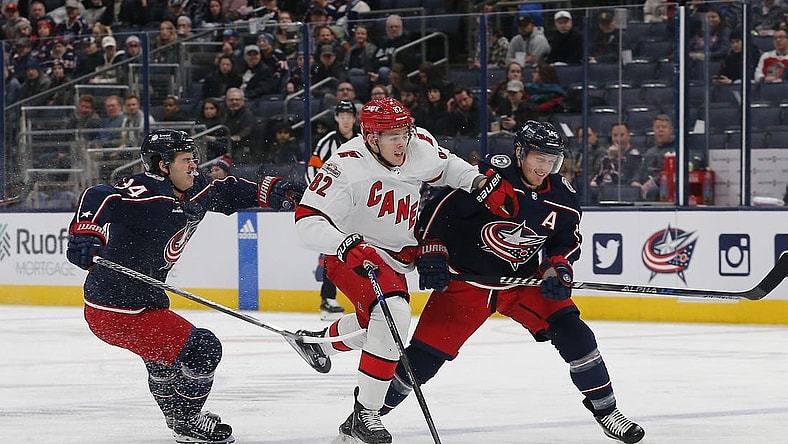 Jan 12, 2023; Columbus, Ohio, USA; Carolina Hurricanes center Jesperi Kotkaniemi (82) avoids then check from Columbus Blue Jackets center Gustav Nyquist (14) during the first period at Nationwide Arena. Mandatory Credit: Russell LaBounty-USA TODAY Sports