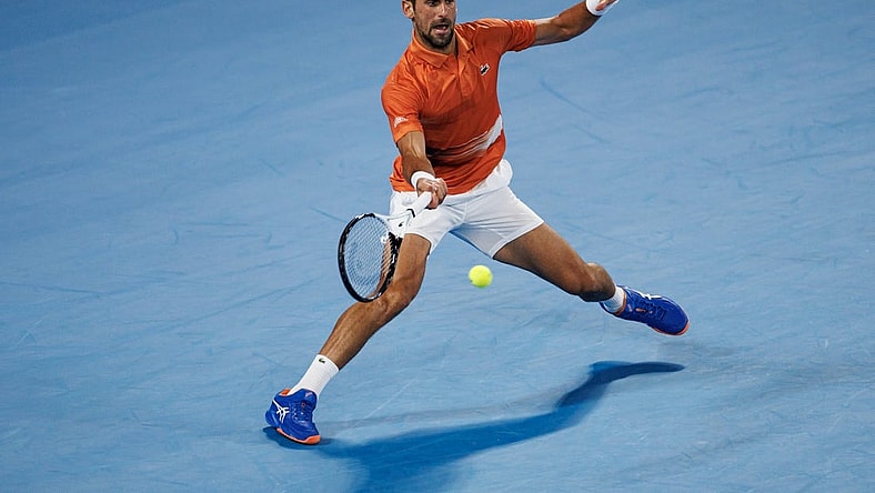 Jan 13, 2023; Melbourne, Victoria, Australia; Novak Djokovic of Serbia hits a shot during an exhibition practice match against Nick Kyrgios of Australia on Rod Laver Arena at Melbourne Park. Mandatory Credit: Mike Frey-USA TODAY Sports