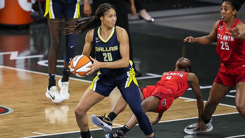 May 27, 2021; College Park, Georgia, USA; Atlanta Dream guard Aari McDonald (4) is knocked to the court by Dallas Wings forward Isabelle Harrison (20) during the first half at Gateway Center Arena at College Park. Mandatory Credit: Dale Zanine-USA TODAY Sports
