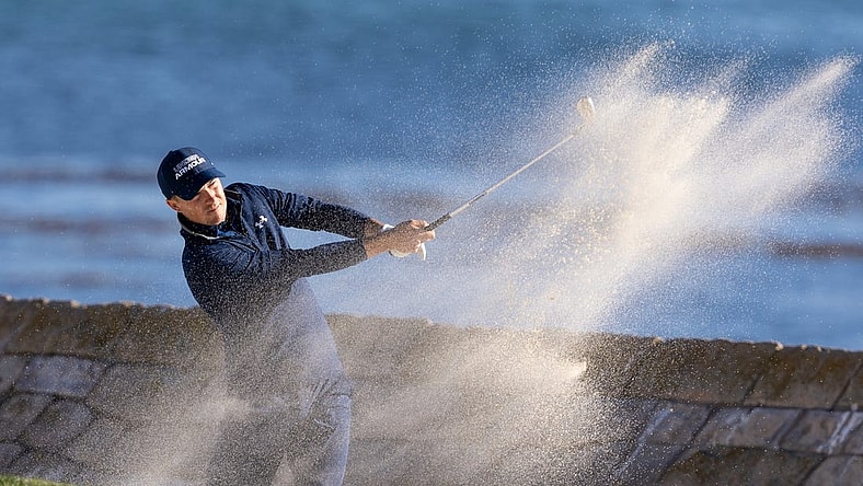Feb 6, 2022; Pebble Beach, California, USA; Jordan Spieth plays a shot from a bunker on the 18th hole during the final round of the AT&T Pebble Beach Pro-Am golf tournament at Pebble Beach Golf Links. Mandatory Credit: Bill Streicher-USA TODAY Sports