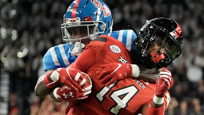 Dec 28, 2022; Houston, Texas, USA;  Texas Tech Red Raiders wide receiver Xavier White (14) is tackled by Mississippi Rebels cornerback Davison Igbinosun (20) in the second half in the 2022 Texas Bowl at NRG Stadium. Mandatory Credit: Thomas Shea-USA TODAY Sports