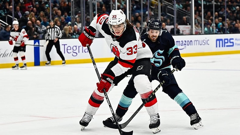 Jan 19, 2023; Seattle, Washington, USA; New Jersey Devils defenseman Ryan Graves (33) protects the puck from Seattle Kraken right wing Oliver Bjorkstrand (22) during the third period at Climate Pledge Arena. Seattle defeated New Jersey 4-3. Mandatory Credit: Steven Bisig-USA TODAY Sports