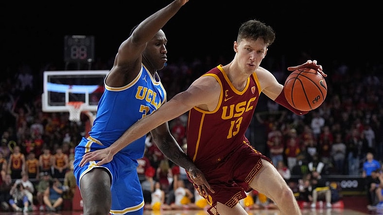 Jan 26, 2023; Los Angeles, California, USA; Southern California Trojans guard Drew Peterson (13) dribbles the ball against UCLA Bruins guard David Singleton (34) in the second half at Galen Center. Mandatory Credit: Kirby Lee-USA TODAY Sports