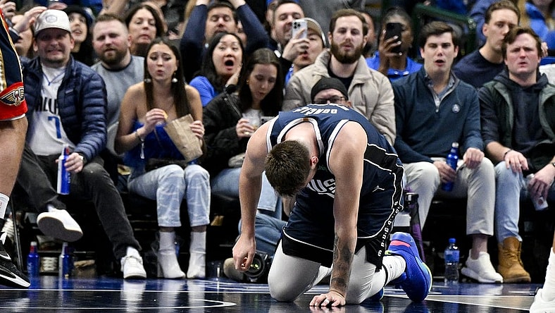 Feb 2, 2023; Dallas, Texas, USA; Dallas Mavericks guard Luka Doncic (77) kneels on the floor after he is fouled by New Orleans Pelicans forward Brandon Ingram (not pictured) as he drives to the basket during the second half at the American Airlines Center. Mandatory Credit: Jerome Miron-USA TODAY Sports