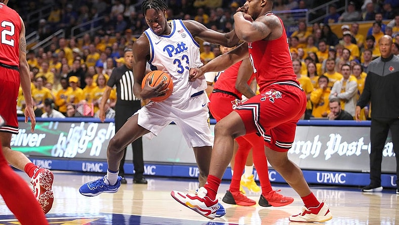 Pittsburgh Panthers Federiko Federiko (33) gets fouled by Louisville Cardinals Sydney Curry (21) while driving to the basket during the first half on February 7, 2023 at the Petersen Events Center in Pittsburgh, PA.

Pittsburgh Panthers Vs Louisville Mens Basketball