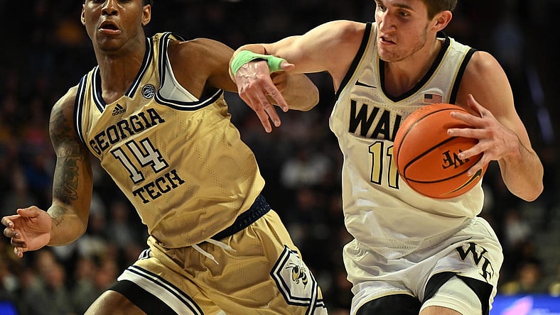 Feb 11, 2023; Winston-Salem, North Carolina, USA; Wake Forest Demon Deacons forward Andrew Carr (11) battles around Georgia Tech Yellow Jackets forward Jalon Moore (14) during the first half at Lawrence Joel Veterans Memorial Coliseum. Mandatory Credit: William Howard-USA TODAY Sports