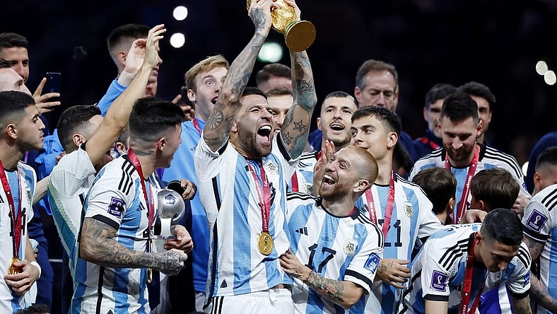 Dec 18, 2022; Lusail, Qatar; Argentina defender Nicolas Otamendi (19) holds up the World Cup trophy as he and his teammates celebrate after winning the 2022 World Cup final against France at Lusail Stadium. Mandatory Credit: Yukihito Taguchi-USA TODAY Sports