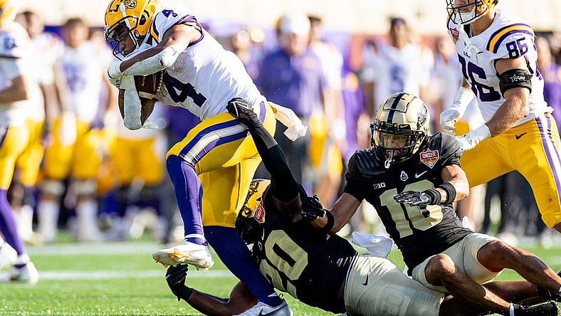 Jan 2, 2023; Orlando, FL, USA; Purdue Boilermakers linebacker OC Brothers (20) and Purdue Boilermakers safety Cam Allen (10) attempt to tackle LSU Tigers running back John Emery Jr. (4) during the second half at Camping World Stadium. Mandatory Credit: Matt Pendleton-USA TODAY Sports
