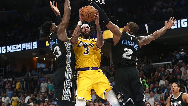 Feb 28, 2023; Memphis, Tennessee, USA; Los Angeles Lakers forward Anthony Davis (3) drives to the basket between Memphis Grizzlies forward Jaren Jackson Jr. (13) and forward Brandon Clark (15) during the second half at FedExForum. Mandatory Credit: Petre Thomas-USA TODAY Sports