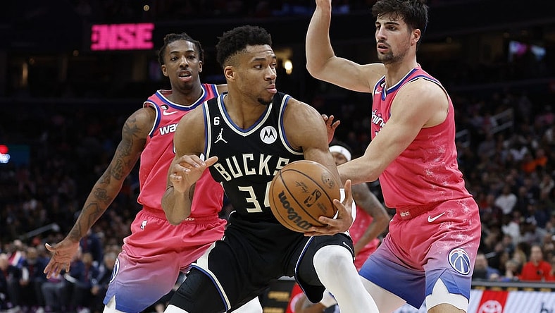 Mar 5, 2023; Washington, District of Columbia, USA; Milwaukee Bucks forward Giannis Antetokounmpo (34) holds the ball as Washington Wizards forward Deni Avdija (9) and Wizards guard Delon Wright (55) defend at Capital One Arena. Mandatory Credit: Geoff Burke-USA TODAY Sports