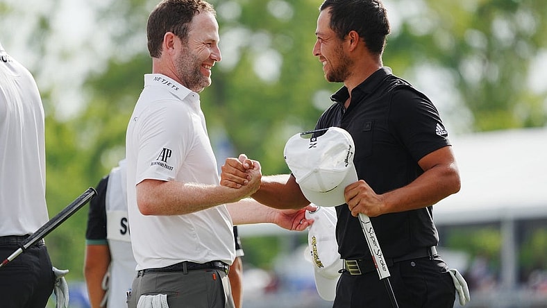 Apr 24, 2022; Avondale, Louisiana, USA; Xander Schauffele (right) embraces Patrick Cantlay (left) on the 18th green during the final round of the Zurich Classic of New Orleans golf tournament. Mandatory Credit: Andrew Wevers-USA TODAY Sports