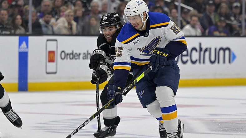 Mar 26, 2023; Los Angeles, California, USA;   St. Louis Blues center Jordan Kyrou (25) and Los Angeles Kings left wing Alex Iafallo (19) battle for the puck in the third period at Crypto.com Arena. Mandatory Credit: Jayne Kamin-Oncea-USA TODAY Sports