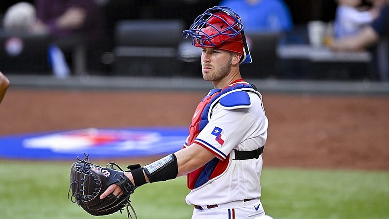 Apr 1, 2023; Arlington, Texas, USA; Texas Rangers catcher Mitch Garver (18) surveys the field during a stoppage in play against the Philadelphia Phillies at Globe Life Field. Mandatory Credit: Jerome Miron-USA TODAY Sports